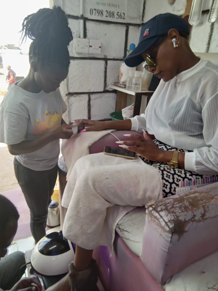 alumni from the Ngong Road Children's Foundation learning hairdressing skills